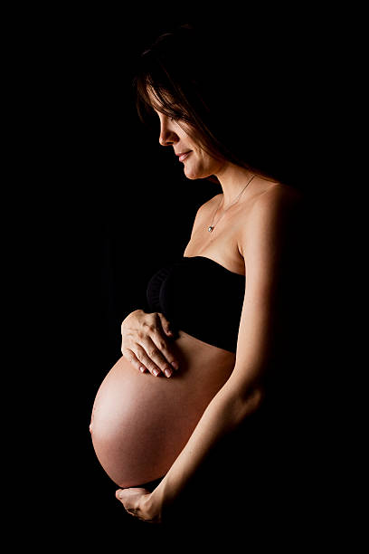 womans żołądka w ciąży - human pregnancy abdomen naked human hand zdjęcia i obrazy z banku zdjęć