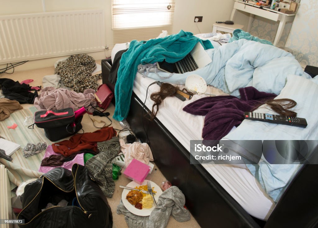 showing mess in a teenage girls bedroom including food,clothes and bags a "floordrobe" showing mess in a teenage girls bedroom with plates of food and messy clothes Messy Stock Photo