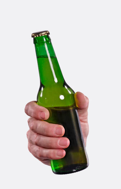 The hand is holding a fresh beer bottle on white background. Hand hold green glass beer bottle on white background. man hand holding candy bar stock pictures, royalty-free photos & images