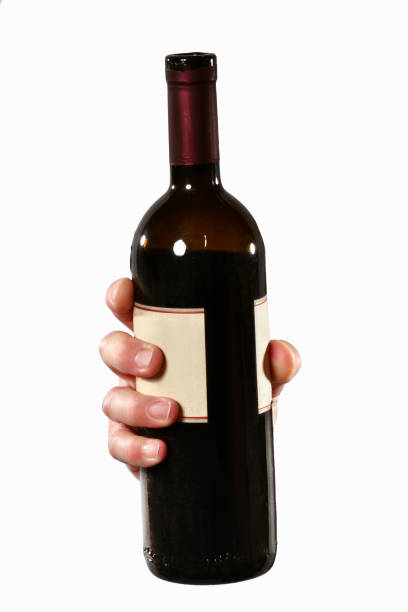The hand hold a red wine bottle t open and to drink.