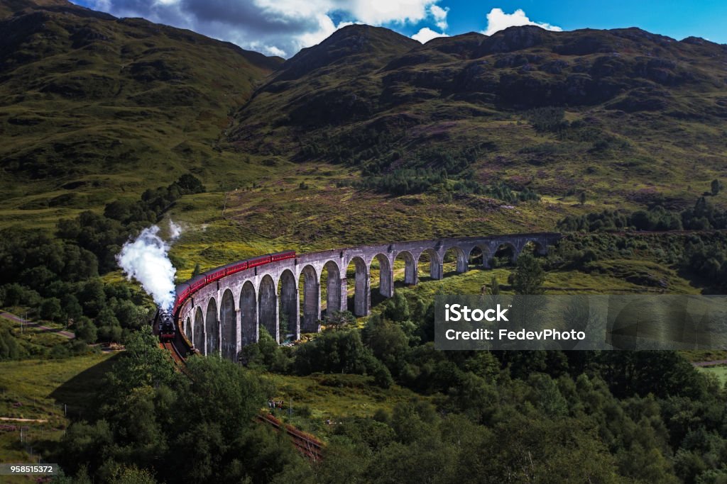 Glenfinnan Railway Viaduct Glenfinnan Railway Viaduct in Scotland with the Jacobite steam train passing over Fort Stock Photo