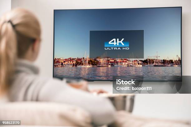 Große Moderne Tv Mit 4 Kauflösungen Und Junge Frau Im Vordergrund Einige Viedeo Stockfoto und mehr Bilder von Fernseher