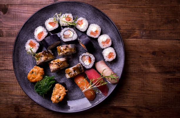스시 초밥 및 롤 갈색 나무 테이블 배경에 설정 합니다. 상위 뷰 음식 사진입니다. copyspace 텍스트와 디자인 요소에 대 한 - food wasabi vegetable tuna 뉴스 사진 이미지
