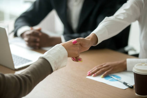 istock Black and white female hands shaking at group meeting, closeup 958531314
