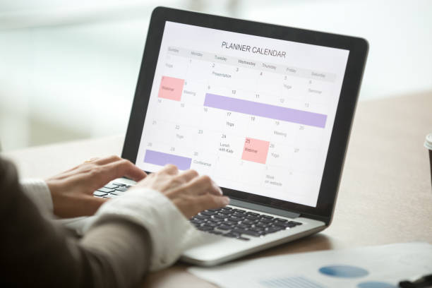 бизнесвумен планирования день с помощью цифрового календаря на ноутбуке, крупным планом зрения - проверка время стоковые фото и изображения