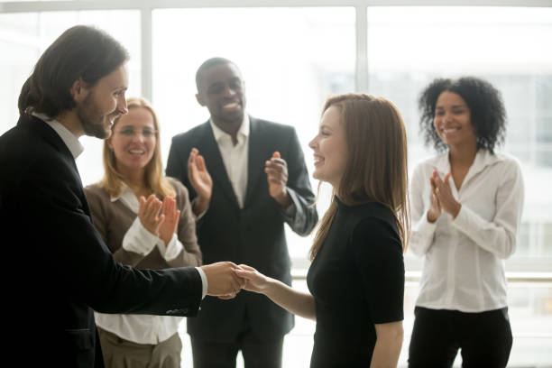 istock Smiling ceo handshaking successful female worker showing respect, team applauding 958531468