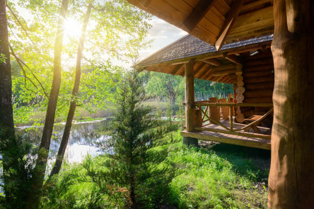 Wooden house and river Wooden house and pond at the sunrise log cabin photos stock pictures, royalty-free photos & images