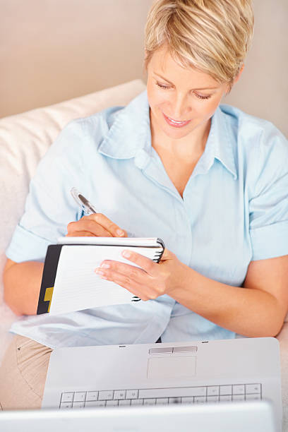 istock Mid adult woman writing notes from the internet 95854559