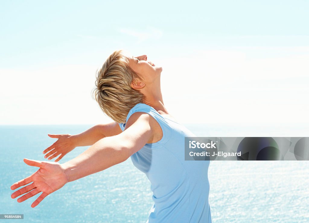 Mujer de mediana edad disfrutar de actividades al aire libre junto al mar - Foto de stock de 30-34 años libre de derechos