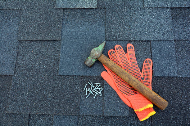 istock Close up view on asphalt roofing shingles background with hammer and nails. 958546642