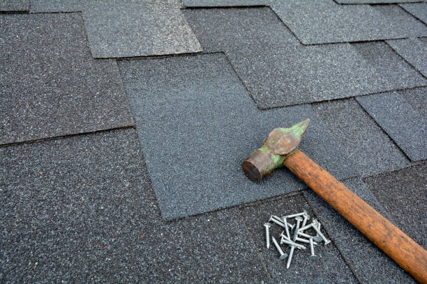 istock Close up view on asphalt roofing shingles background with hammer and nails. 958546682