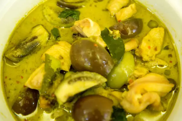 Photo of Thai chicken green curry with old wooden background.closeup green curry with chicken (Kang Keaw Wan Gai)