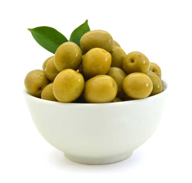 istock pickled green olives in a bowl and olive tree branch on a white background 958550502