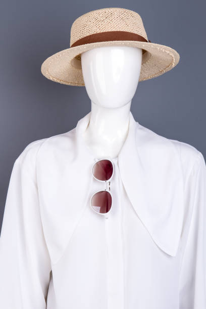 Mannequin in white blouse and straw hat.