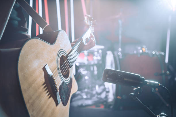 istock The Studio microphone records an acoustic guitar close-up. Beautiful blurred background of colored lanterns. 958552616