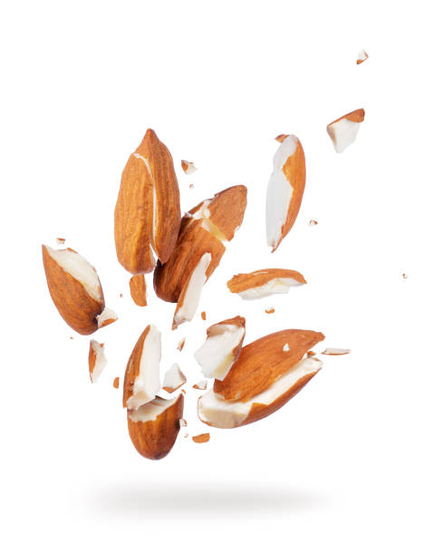 Almonds crushed into pieces, frozen in the air close-up on a white background Almonds crushed into pieces, frozen in the air close-up on a white background almond slivers stock pictures, royalty-free photos & images