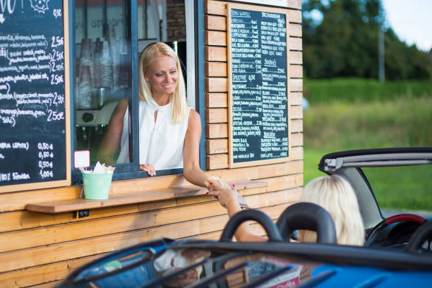 istock Drive-in caffe female clerk with sandwich 958559220