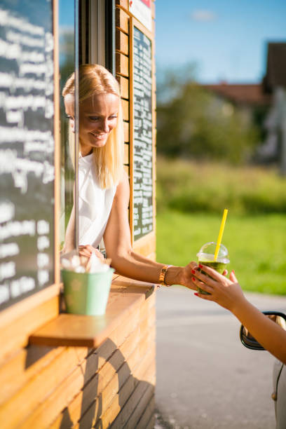istock Drive-in caffe female clerk with smoothie 958559260