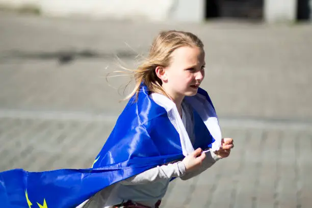 Photo of happy young blonde girl demonstrator sporting the European flag