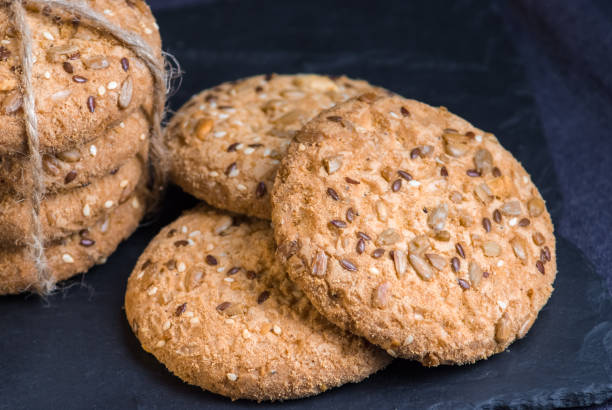 istock Savory cookies sprinkled with sesame seeds, sunflower on shale board 958565884
