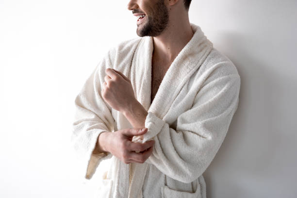 ragazzo ottimista è appoggiato al muro in camappato bianco - housecoat foto e immagini stock