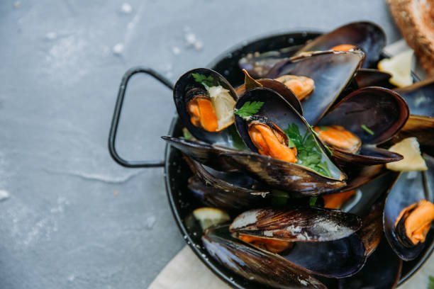 istock Shellfish Mussels with lemon and herbs. Shellfish seafood. Top view. 958569018