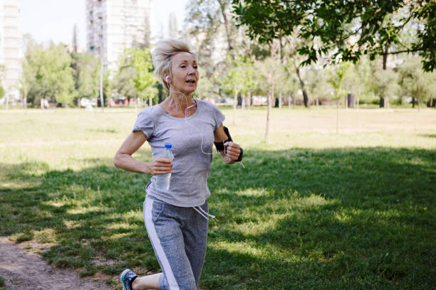 istock Senior woman jogging in park 958569118