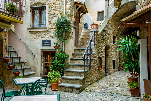IMPERIA, LIGURIA, ITALY - APRIL 15, 2018: Typical alley of the village with stone steps in the historic center of Seborga, counted among the most beautiful villages in Italy.