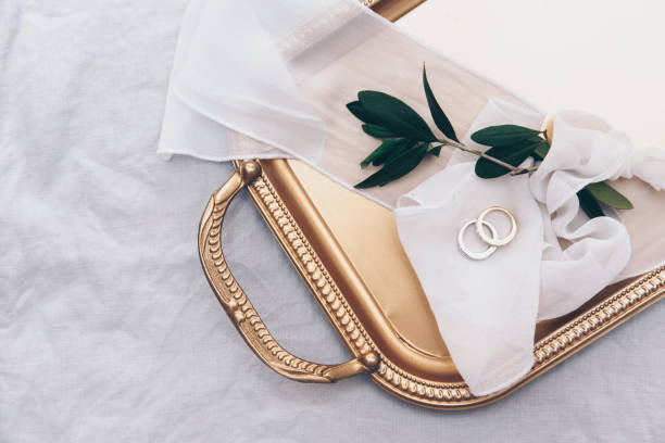 istock Wedding rings. Wedding symbols, attributes. Holiday celebration. Items on a gold  tray. 958569438