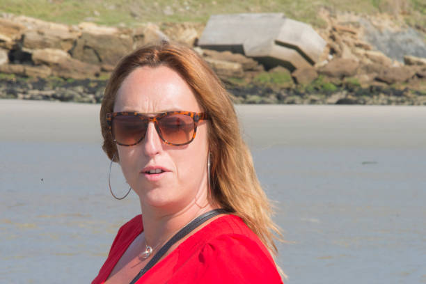 istock Stylish young woman on a normandy beach with sunglasses 958570010