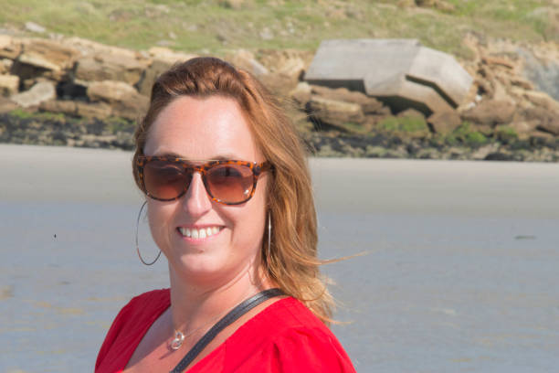 istock Stylish young woman on a normandy beach with sunglasses 958570068