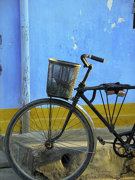 Old bike against colorful blue wall stock photo