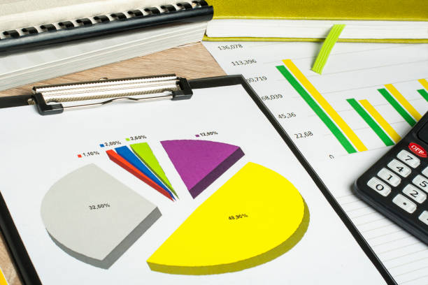 Charts, accounting books and calculator on wooden office table. Financial and budget concept. stock photo