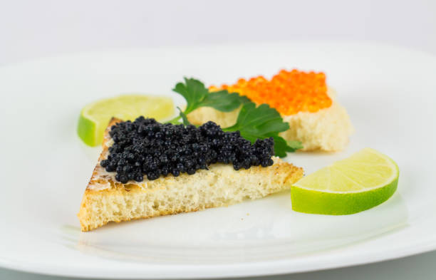 istock Black and red caviar on roasted bread served on white plate 958583548