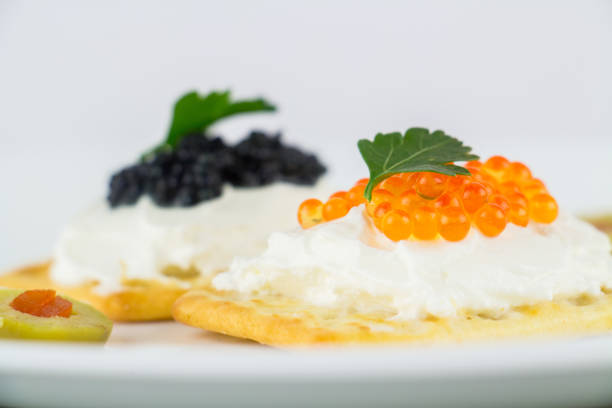 istock Black and red caviar on roasted bread served on white plate 958583678