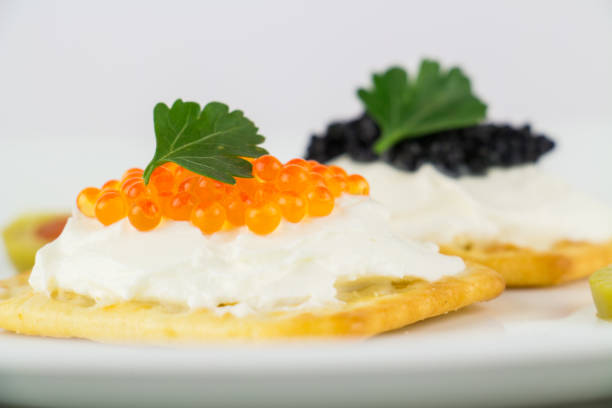 istock Black and red caviar on roasted bread served on white plate 958584224