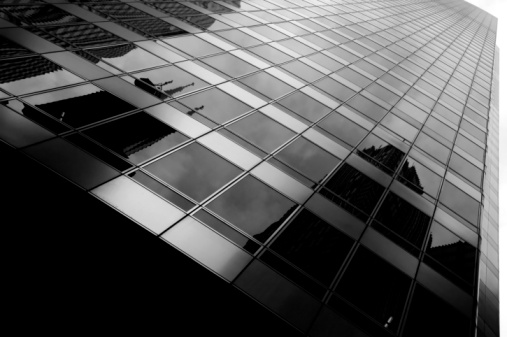 Abstract pattern of skyscrapers windows with reflections of blue sky and other business buildings. Abstract corporate business or architecture background.