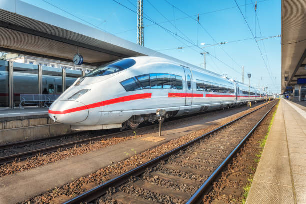 istock High speed white train on the railway station at sunset. Nuremberg, Germany. Modern intercity train on the railway platform. Industrial. Amazing passenger train on railroad. Transportation. Europe 958608388