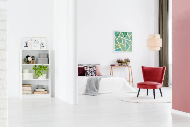 istock Minimalist bedroom with red chair 958608860