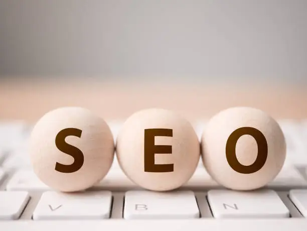 Photo of Search engine optimization concept. Wood block sphere shape on computer keyboard with word SEO and empty copy space for your text