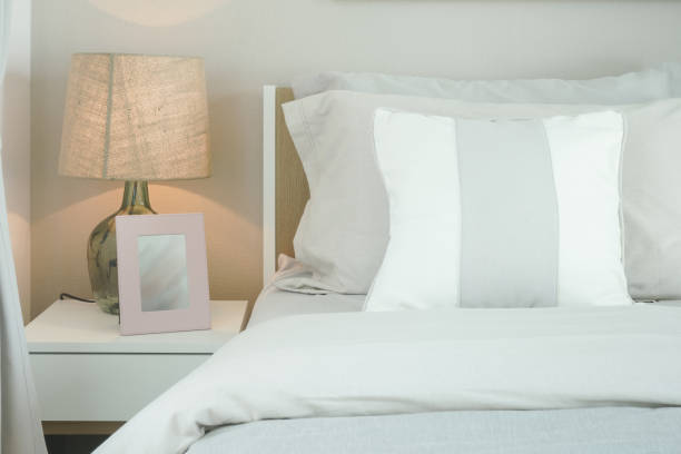 istock Close up pillows on bed with reading lamp and picture frame 958616042