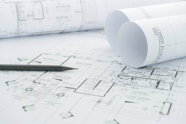 architects workplace - architectural blueprints with measuring tape and black pencil on table. stock photo