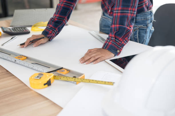 istock Engineer woman working blueprint at a drawings in office. Engineering tools and construction concept. 958619226