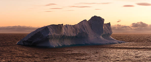 Large Iceberg Floating in Sea at Dusk stock photo
