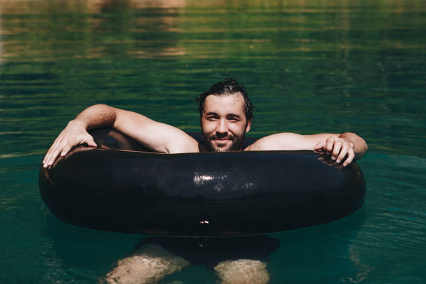 istock Happy man floating around in the water 958634890