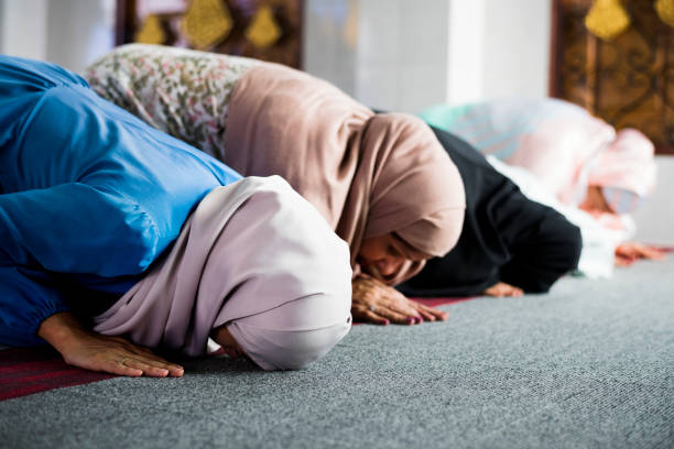 muslim women praying in the mosque during ramadan - islam praying mosque ramadan imagens e fotografias de stock