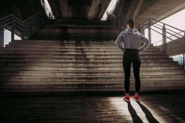 woman preparing for run up the stairs - determination running staircase jogging imagens e fotografias de stock