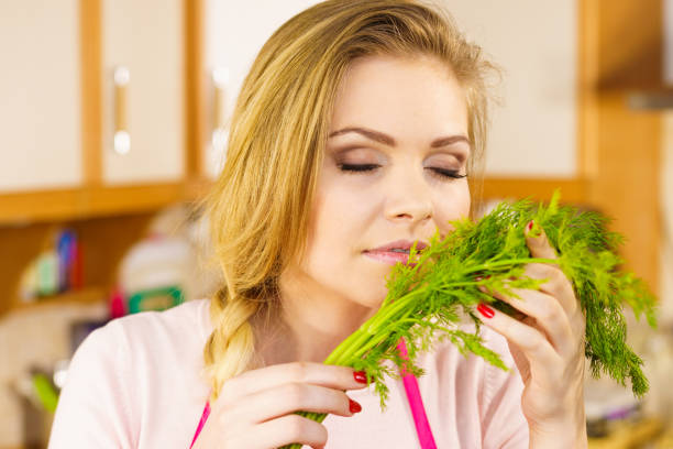 istock Young woman holding dill herb 958658538
