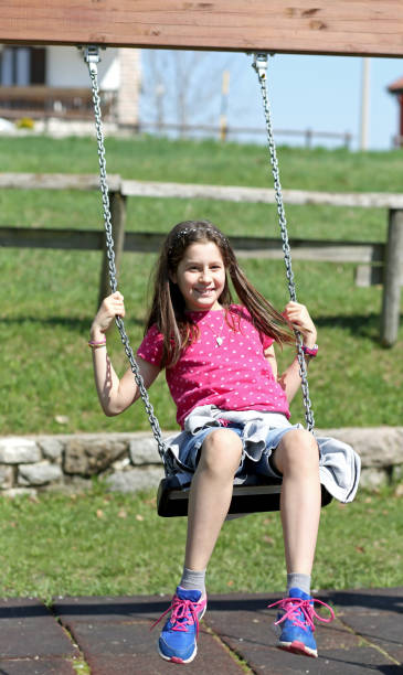 istock little girl plays by going in the swing 958660030