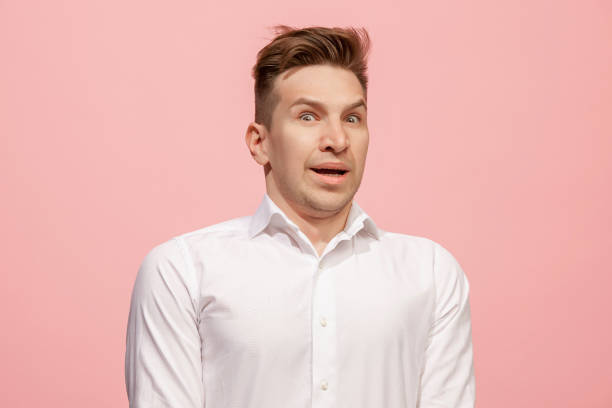 istock Handsome man looking suprised isolated on pink 958664208
